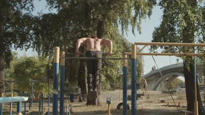 Strong Athlete Doing Gymnastic Exercise on Crossbar.