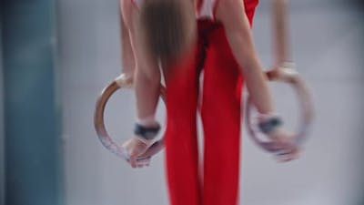 A Little Boy Doing Gymnastic Exercises on the Rings.