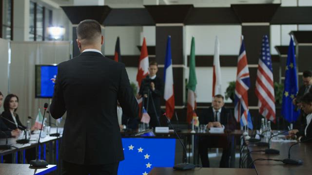 Politicians at a conference listening to speech.