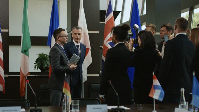 Politician speaking surrounded by reporters .