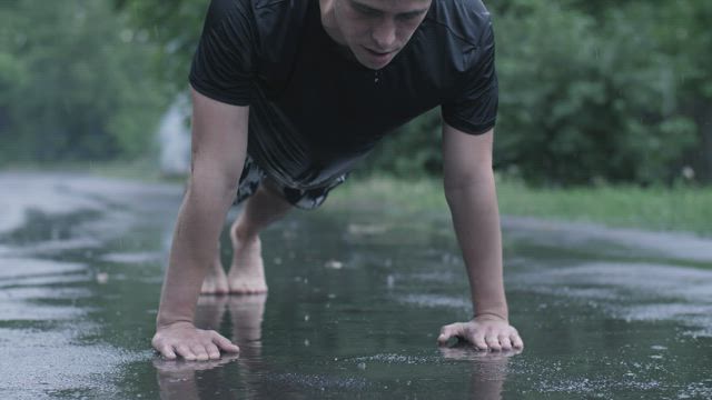 Man training outdoors while raining.