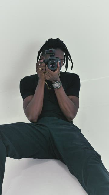 Photographer sitting on the floor on a white background.