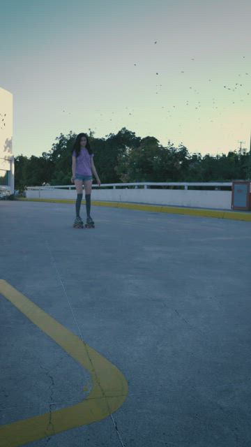 Young urban woman skating slowly during sunset.