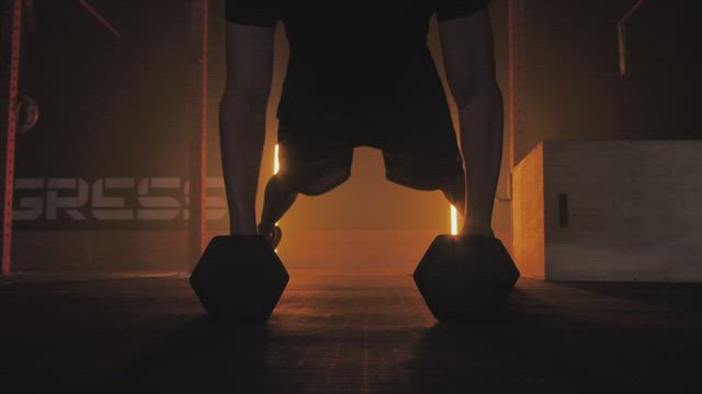 Man doing push ups using dumbbells.