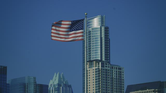 Flag of the United States waving on top of a flagpole.