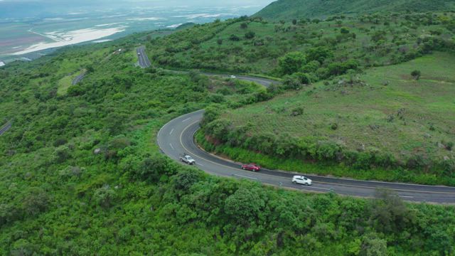 Curvy road on a tree covered hill.