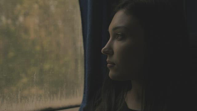 Nostalgic girl looking thru a window bus.