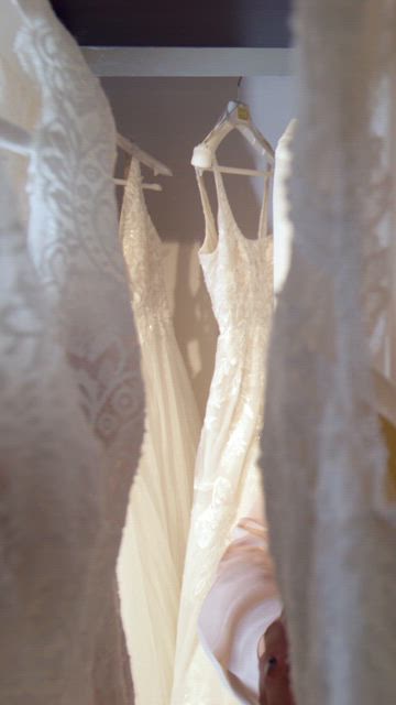 A couple of young women perusign trough the wedding gown wardrobe at the dress store.